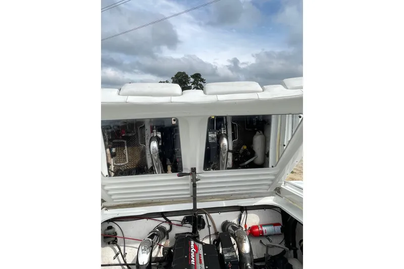 Slide: The Image of Engine compartment of a 1999 Formula 271 FASTech boat with visible components and cloudy sky. - 32