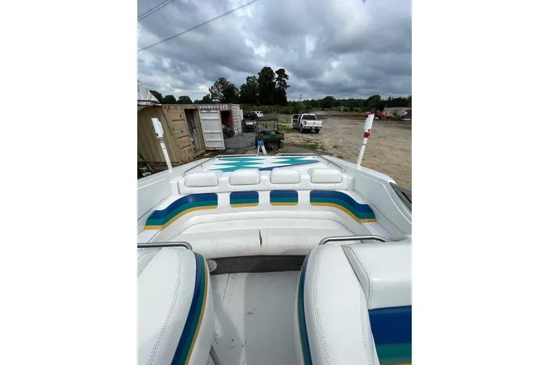 Slide: The Image of 1999 Formula 271 FASTech boat interior with colorful seating, parked outdoors under cloudy skies. - 45