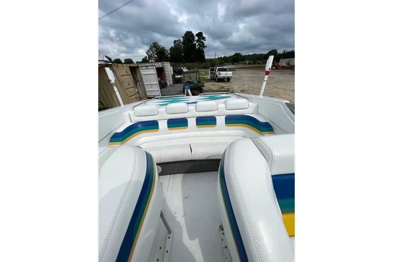 Slide: The Image of 1999 Formula 271 FASTech boat interior with colorful seating, parked outdoors under cloudy skies. - 46