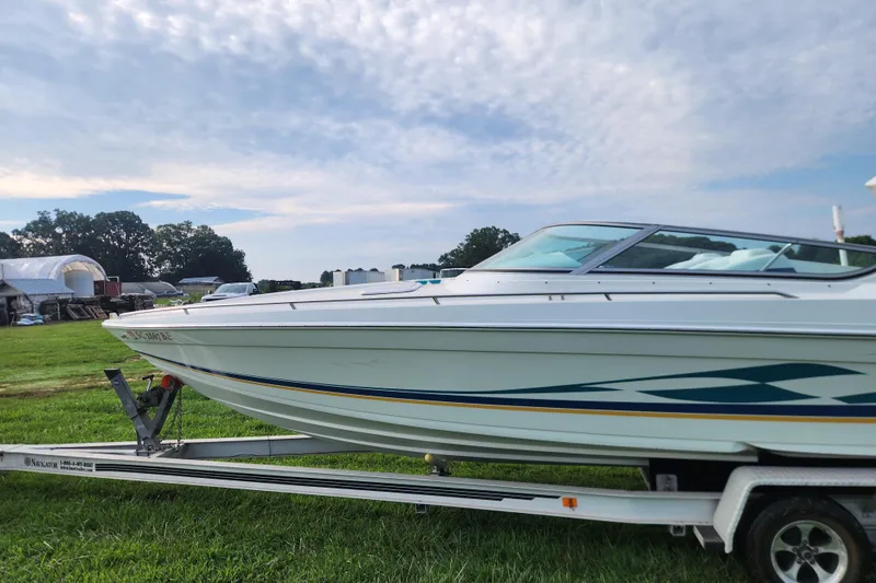 Slide: The Image of 1999 Formula 271 FASTech boat on trailer, parked on grassy field under cloudy sky. - 8