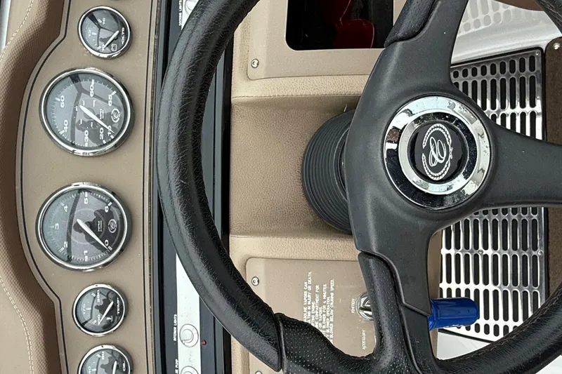 Slide: The Image of Steering wheel and dashboard of a 2007 Cobalt 232 boat with gauges. - 17