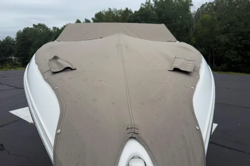 Slide: The Image of Covered 2007 Cobalt 232 boat parked on asphalt, surrounded by trees. - 18