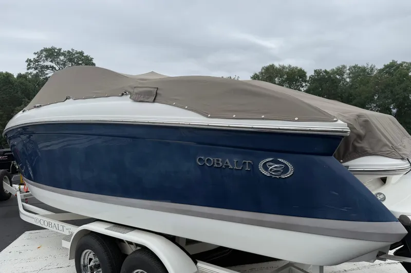 Slide: The Image of 2007 Cobalt 232 boat with cover on trailer, parked outdoors. - 19