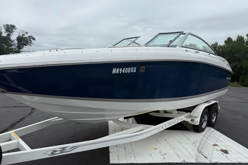 Slide: The Image of 2007 Cobalt 232 boat on trailer, blue and white, parked on asphalt. - 9