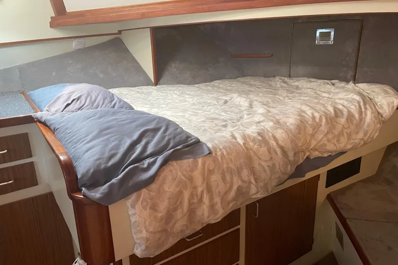 Slide: The Image of Cozy cabin bed in 1978 Delta Marine 43 Trawler with wooden accents and storage. - 18