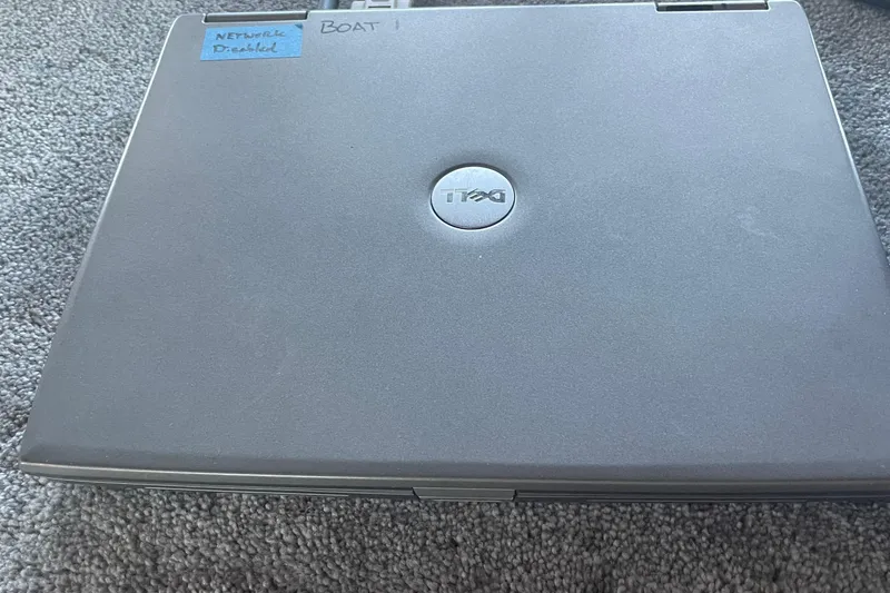 Slide: The Image of Closed Dell laptop with a label reading "Network Disabled, Boat 1" on carpet. - 25