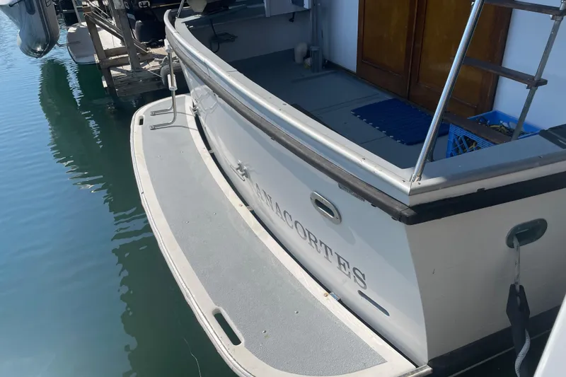 Slide: The Image of 1978 Delta Marine 43 Trawler docked, rear view with wooden doors and water reflection. - 49