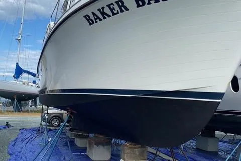 Slide: The Image of 1978 Delta Marine 43 Trawler on dry dock, named "Baker Bay," with blue tarp underneath. - 51