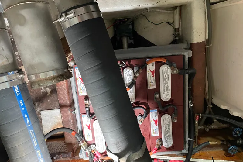 Slide: The Image of Engine room of a 1978 Delta Marine 43 Trawler showing battery setup and piping. - 58