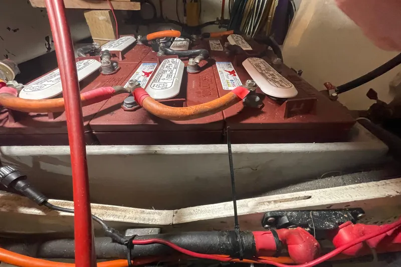 Slide: The Image of Battery compartment of a 1978 Delta Marine 43 Trawler with connected cables. - 60