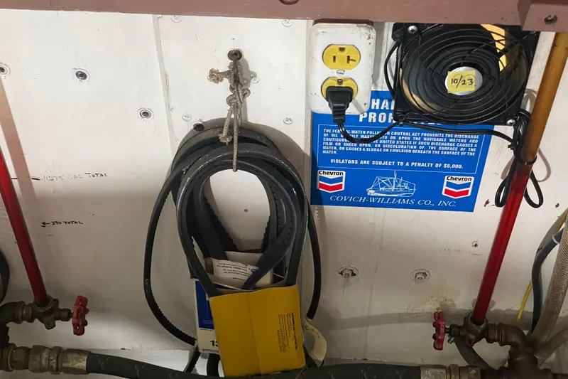 Slide: The Image of Engine room of 1978 Delta Marine 43 Trawler with belts, fan, and safety sign. - 61