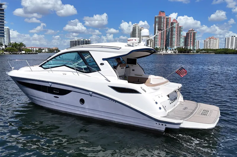 The Image of 2017 Sea Ray Sundancer 350 Coupe yacht on water with city skyline background. - 0