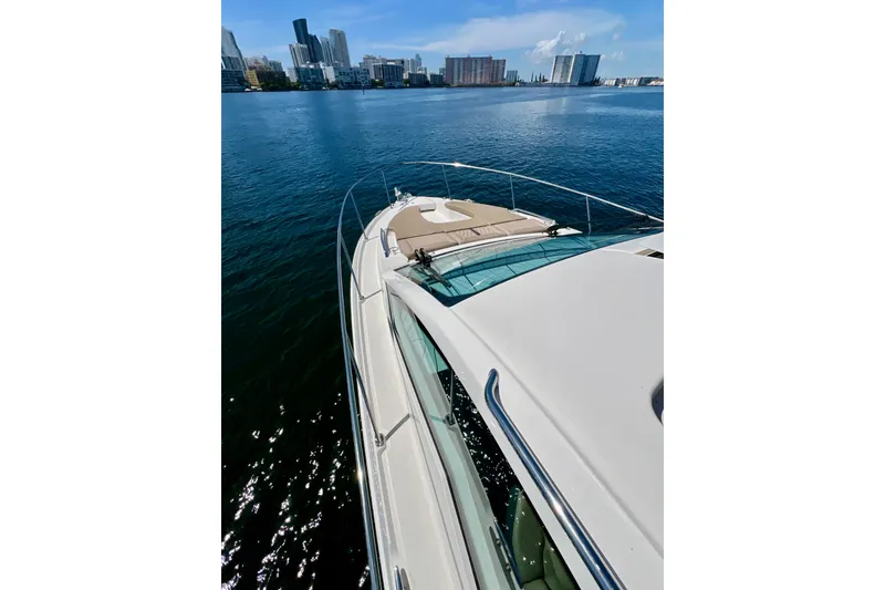 Slide: The Image of 2017 Sea Ray Sundancer 350 Coupe cruising near city skyline on calm water. - 26
