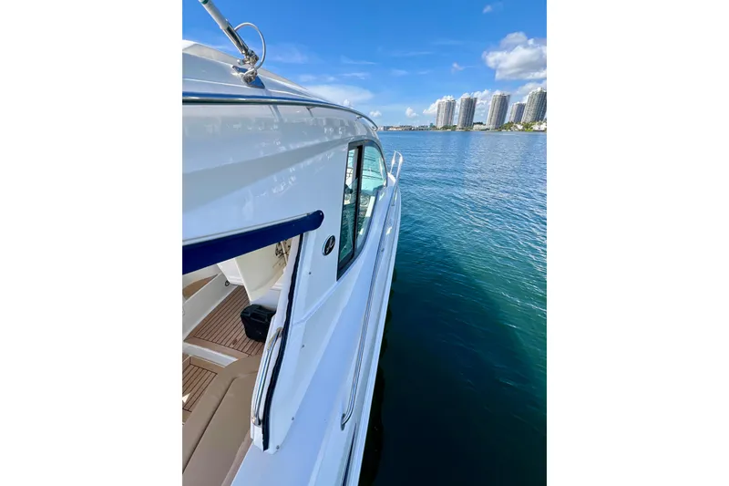 Slide: The Image of 2017 Sea Ray Sundancer 350 Coupe on calm water with city skyline. - 32