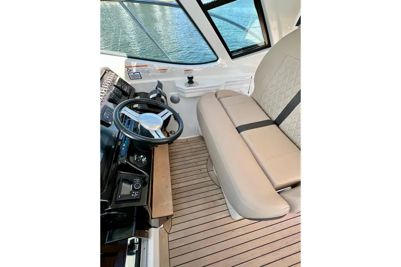 Slide: The Image of 2017 Sea Ray Sundancer 350 Coupe interior with steering wheel and beige seating. - 37