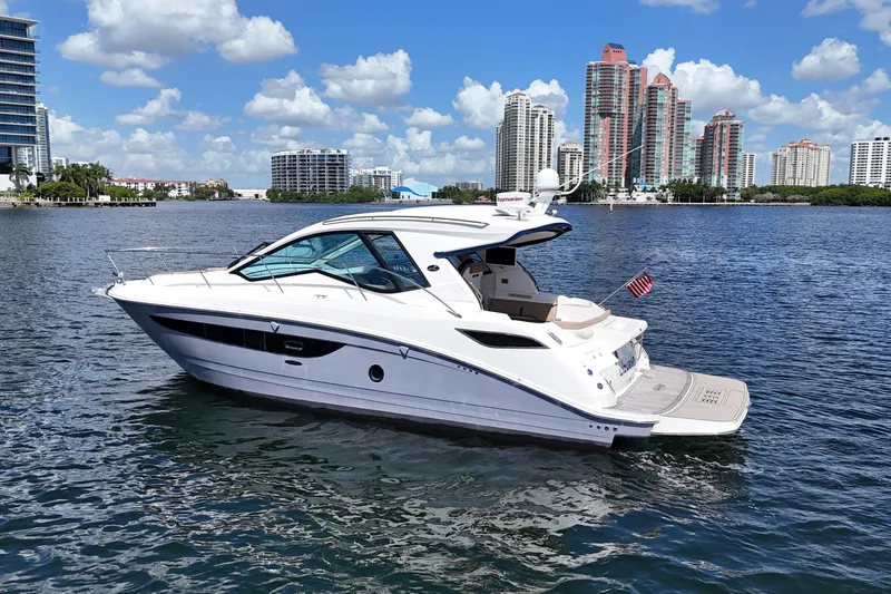 Slide: The Image of 2017 Sea Ray Sundancer 350 Coupe yacht on water with city skyline background. - 9