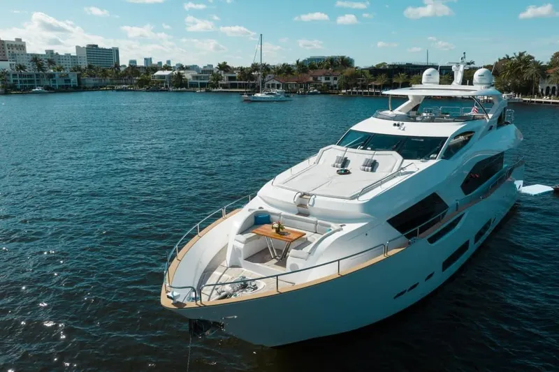 Slide: The Image of Luxurious 2018 Sunseeker 95 Yacht on serene water with cityscape backdrop. - 1
