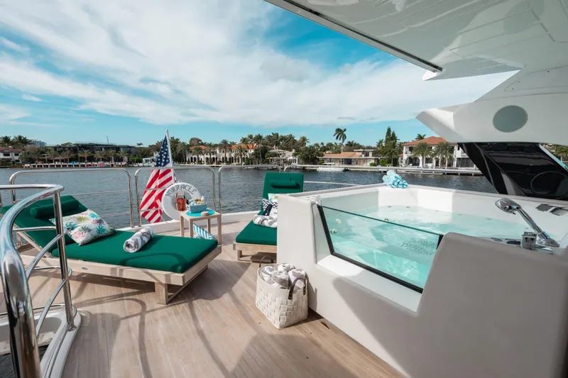 Slide: The Image of Luxurious 2018 Sunseeker 95 Yacht deck with jacuzzi, sun loungers, and scenic waterfront view. - 21