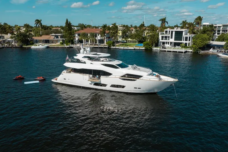 Slide: The Image of Luxurious 2018 Sunseeker 95 Yacht on serene water, surrounded by elegant waterfront homes. - 5