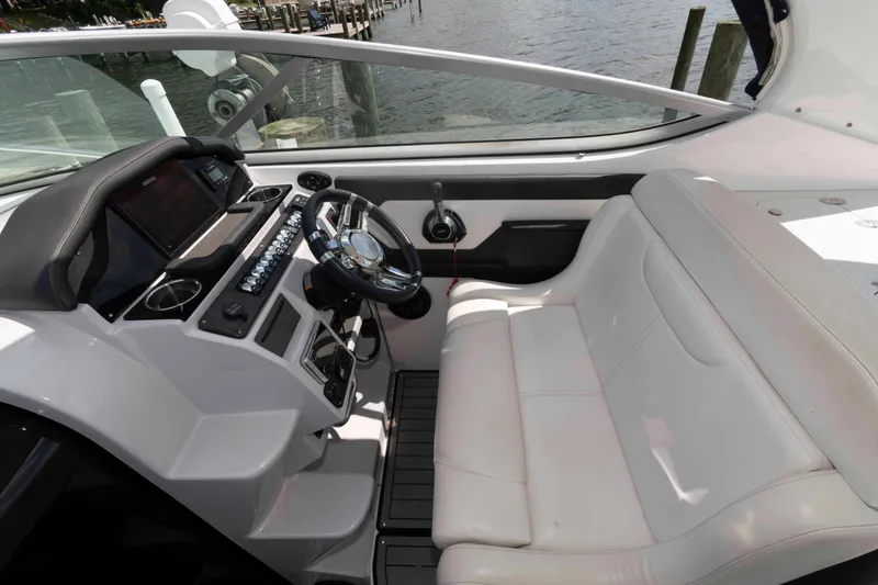 Slide: The Image of 2019 Rinker 290 EX boat cockpit with white seating and modern steering console. - 4