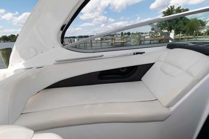 Slide: The Image of 2019 Rinker 290 EX boat interior with white seating and waterfront view. - 7