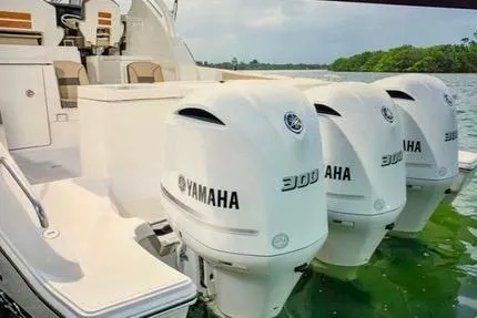 Slide: The Image of 2022 Pursuit OS 355 Offshore yacht kitchen with wood cabinetry, sink, microwave, and cooktop. - 10