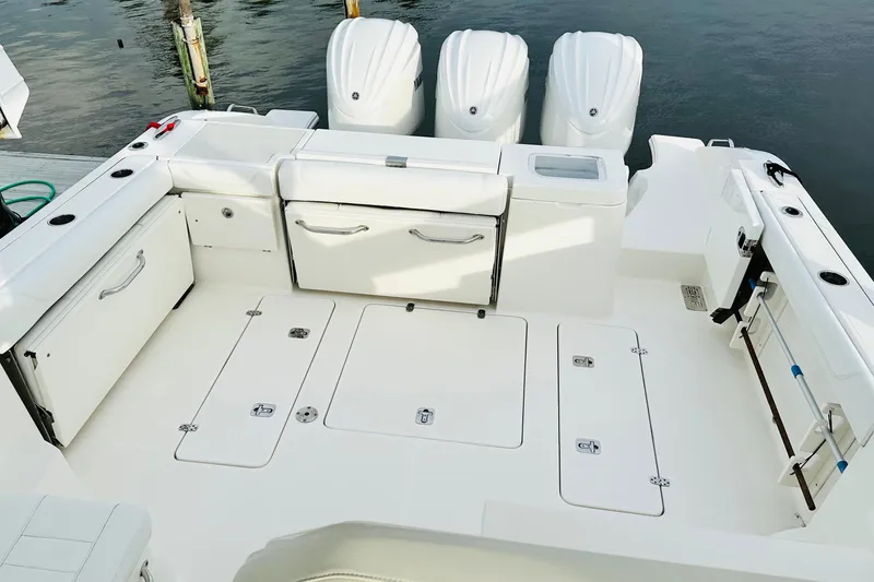 Slide: The Image of 2022 Pursuit OS 355 Offshore cabin interior with wood paneling and bed. - 13