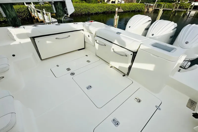 Slide: The Image of Empty storage compartment on 2022 Pursuit OS 355 Offshore boat with wooden trim. - 15