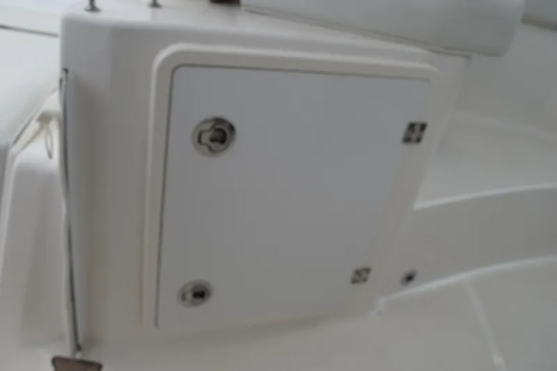 Slide: The Image of 2022 Pursuit OS 355 Offshore boat interior with open storage compartment by the water. - 197