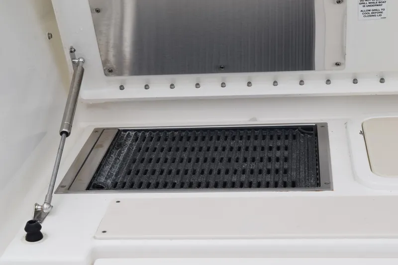 Slide: The Image of 2022 Pursuit OS 355 Offshore boat interior with storage compartment and speaker. - 219