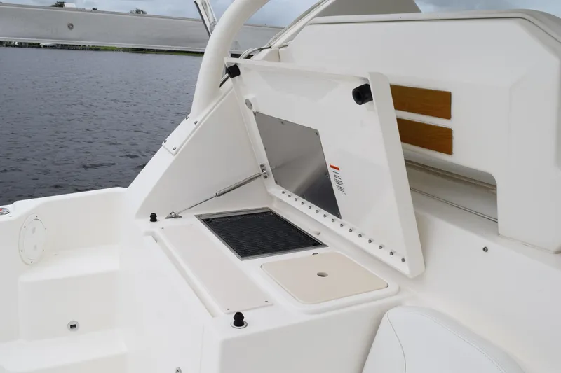Slide: The Image of 2022 Pursuit OS 355 Offshore boat interior with white seating and storage compartments. - 227