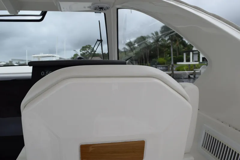 Slide: The Image of 2022 Pursuit OS 355 Offshore boat interior with white seating and stainless steel handle. - 232