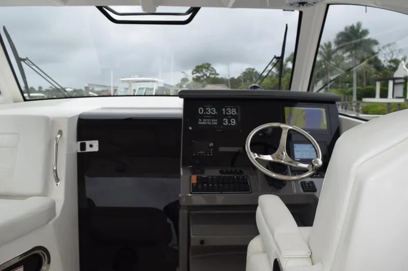 Slide: The Image of Interior detail of 2022 Pursuit OS 355 Offshore boat, featuring white upholstery and metal handle. - 233