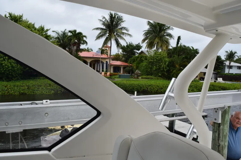 Slide: The Image of 2022 Pursuit OS 355 Offshore boat interior with white cushioned seating and stainless steel handle. - 242