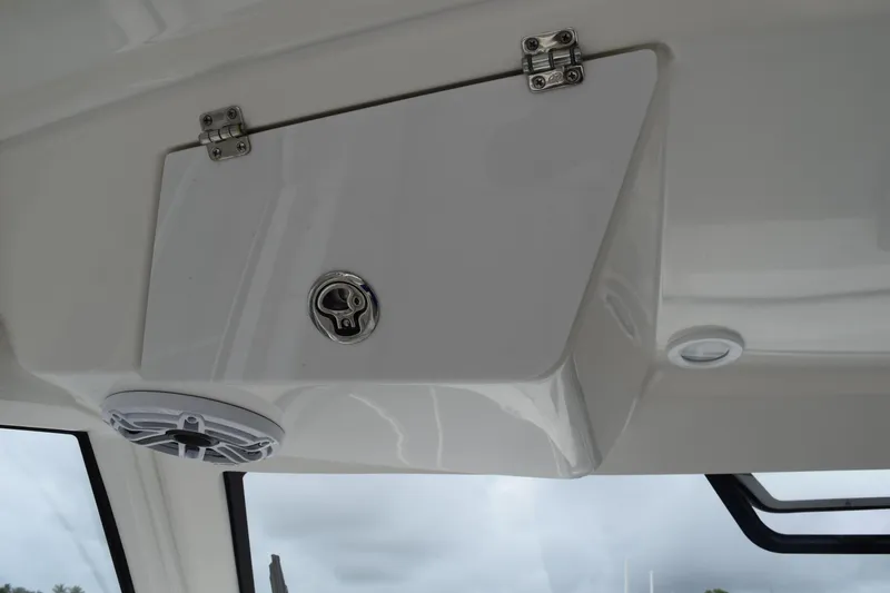 Slide: The Image of 2022 Pursuit OS 355 Offshore helm with white captain's seat and steering wheel. - 250