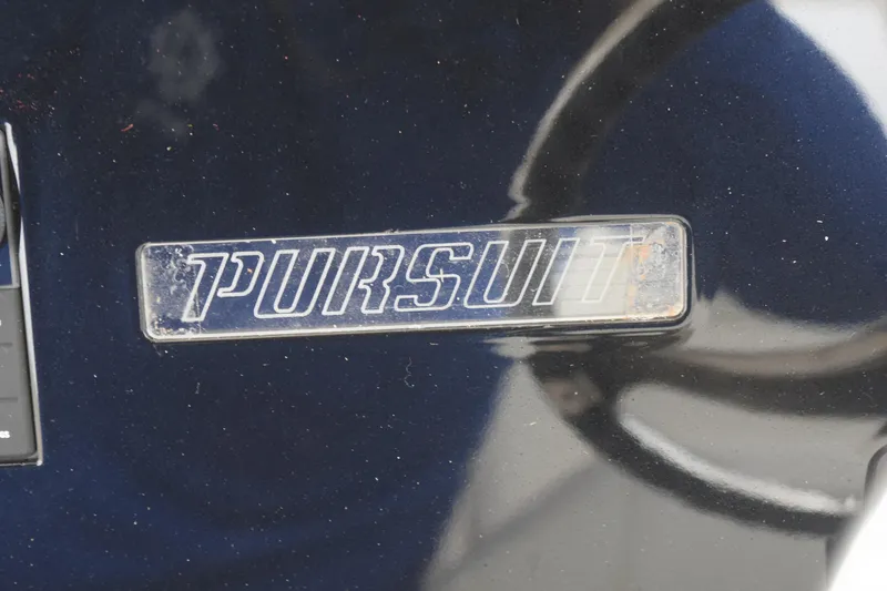 Slide: The Image of 2022 Pursuit OS 355 Offshore boat docked by a scenic waterfront with lush greenery. - 309