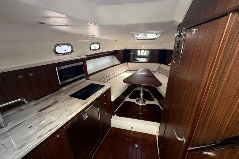Slide: The Image of 2022 Pursuit OS 355 Offshore boat interior with white seating and storage compartment. - 32