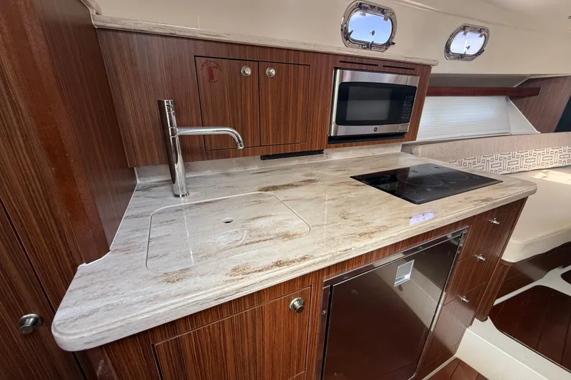 Slide: The Image of 2022 Pursuit OS 355 Offshore boat interior seating with white upholstery. - 33