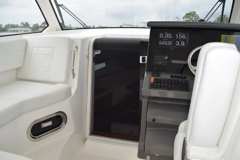 Slide: The Image of 2022 Pursuit OS 355 Offshore cabin entrance with view of deck and palm trees. - 347