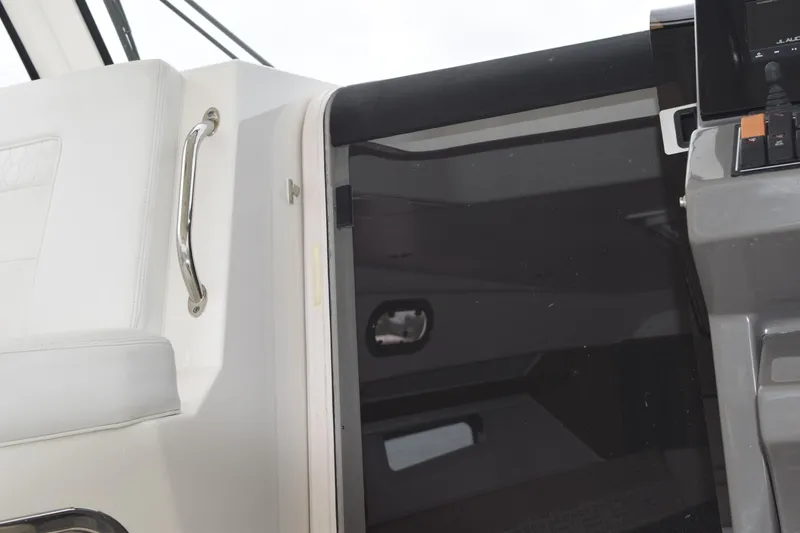 Slide: The Image of Interior view of 2022 Pursuit OS 355 Offshore boat, featuring wooden paneling and open cabin door. - 349