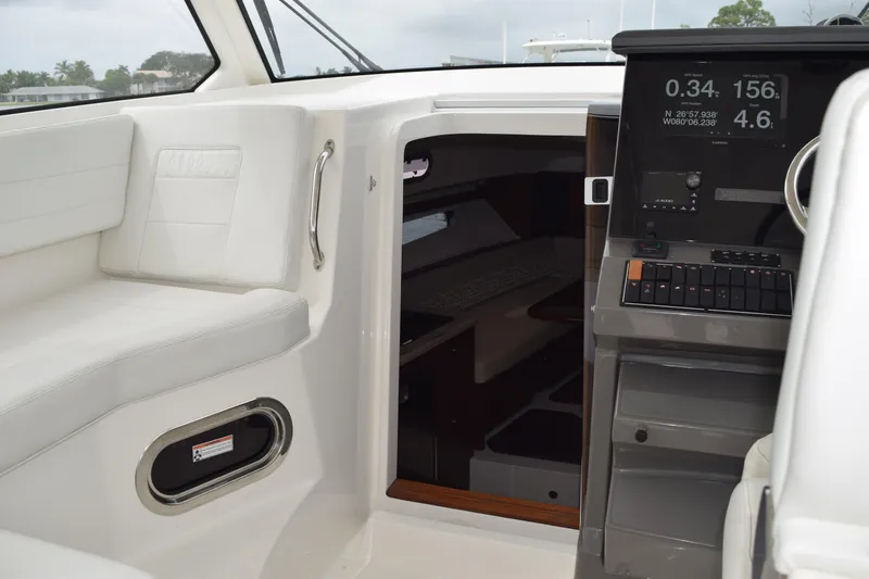 Slide: The Image of Interior view of 2022 Pursuit OS 355 Offshore boat, showing cabin door and seating area. - 356