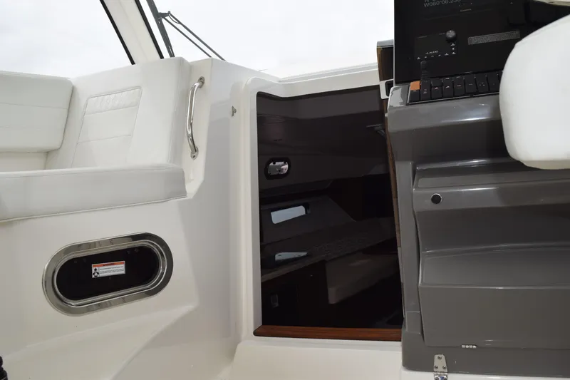 Slide: The Image of 2022 Pursuit OS 355 Offshore interior with wooden steps and safety gear. - 357