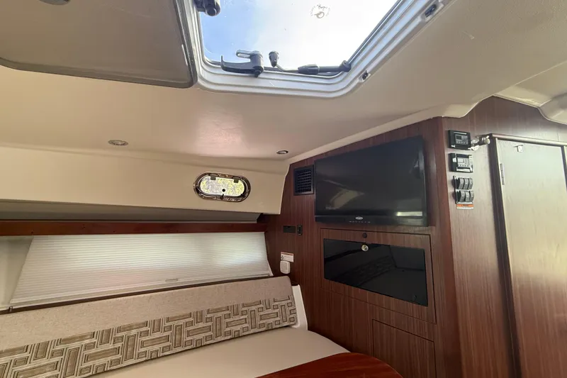 Slide: The Image of 2022 Pursuit OS 355 Offshore boat interior with storage compartment and cushioned seat. - 36