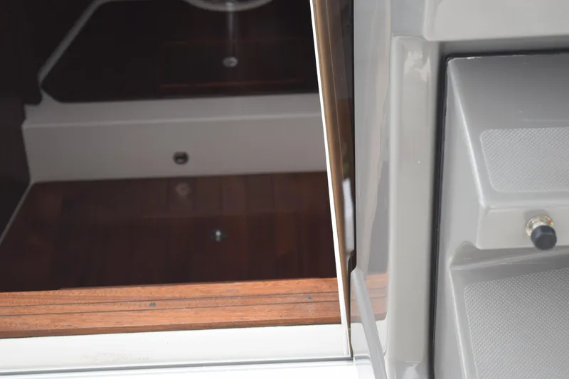 Slide: The Image of Interior view of 2022 Pursuit OS 355 Offshore boat, showcasing cabin entrance and wood paneling. - 362