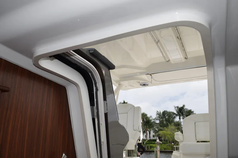 Slide: The Image of Control panel on 2022 Pursuit OS 355 Offshore boat with labeled switches and warning sign. - 370