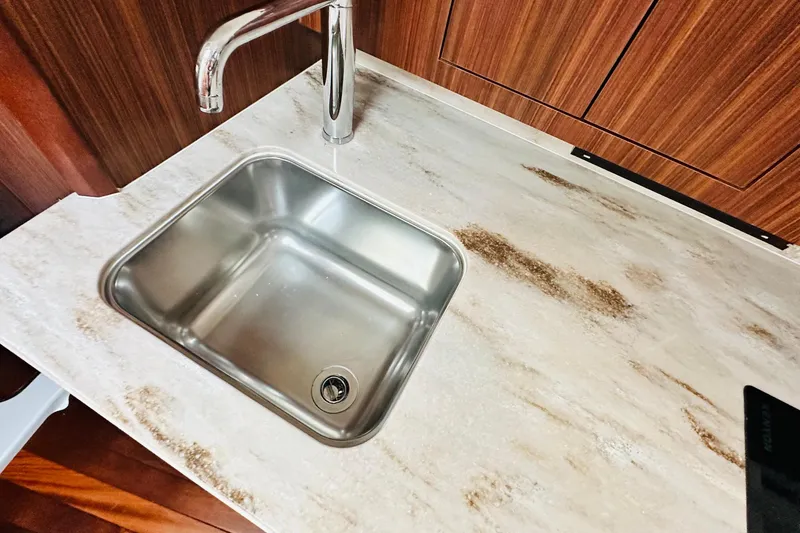 Slide: The Image of Storage compartment on 2022 Pursuit OS 355 Offshore boat with ropes and blue container. - 38