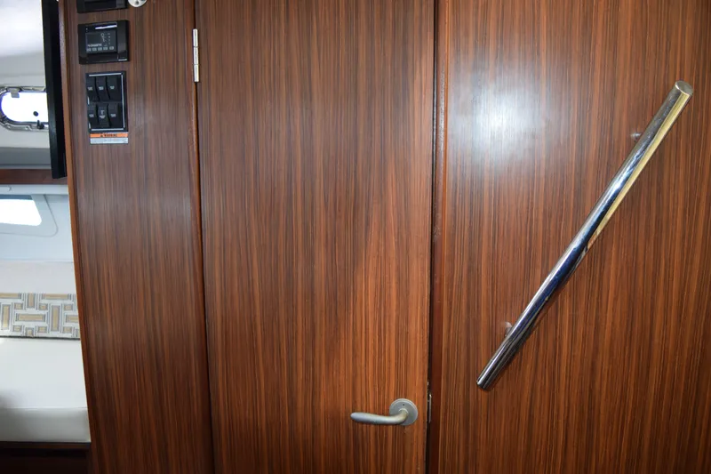 Slide: The Image of Flat-screen TV mounted on wood panel inside 2022 Pursuit OS 355 Offshore boat. - 398