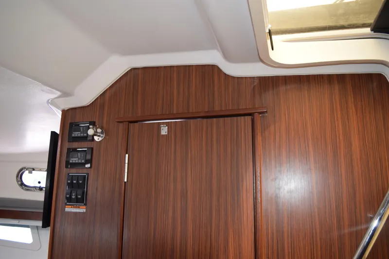 Slide: The Image of 2022 Pursuit OS 355 Offshore interior with wood paneling and built-in entertainment system. - 399