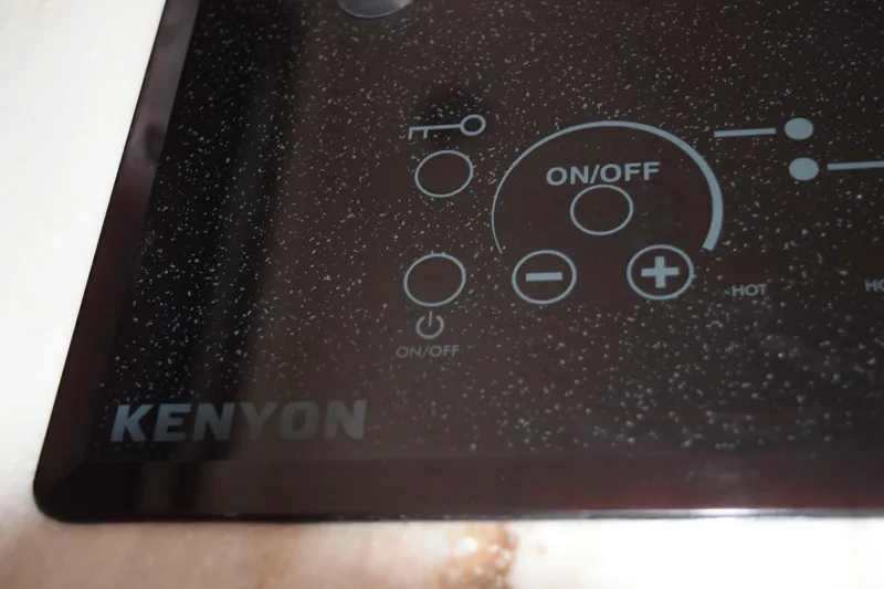 Slide: The Image of 2022 Pursuit OS 355 Offshore boat refrigerator, open with empty shelves and door storage. - 420