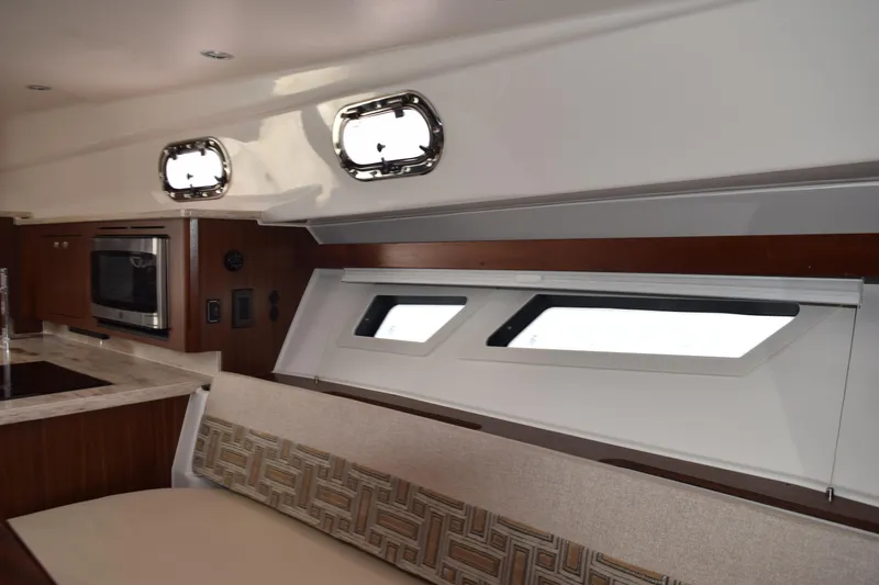 Slide: The Image of Interior of 2022 Pursuit OS 355 Offshore boat with elegant seating and wooden table. - 433